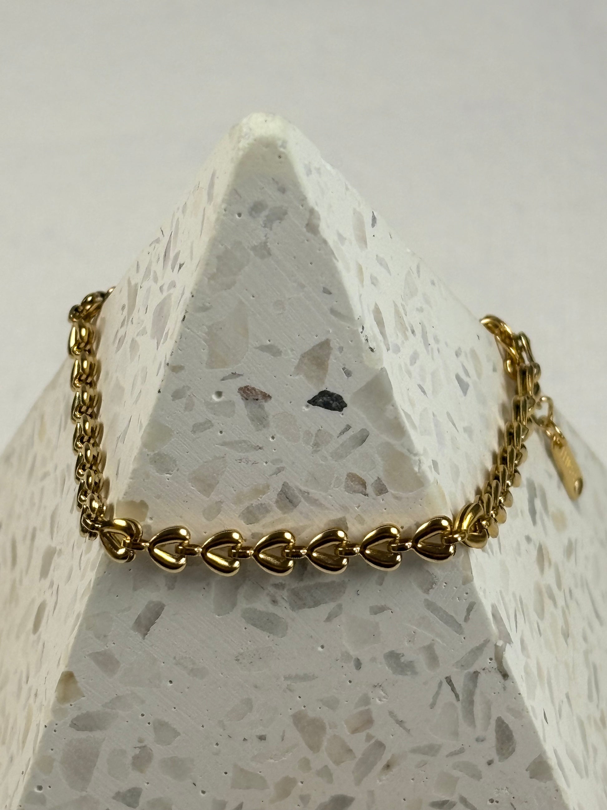 Gold chain bracelet on a textured stone surface