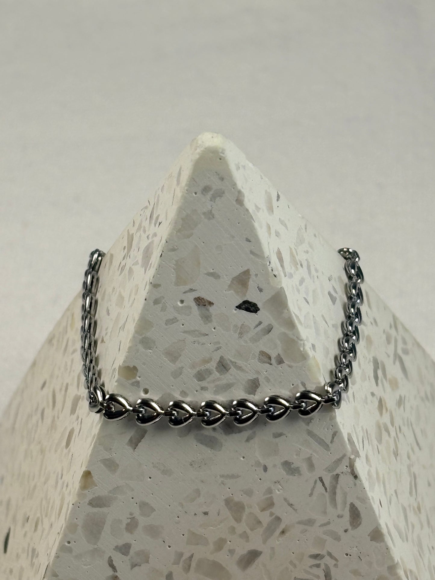 Silver chain bracelet on a textured stone surface