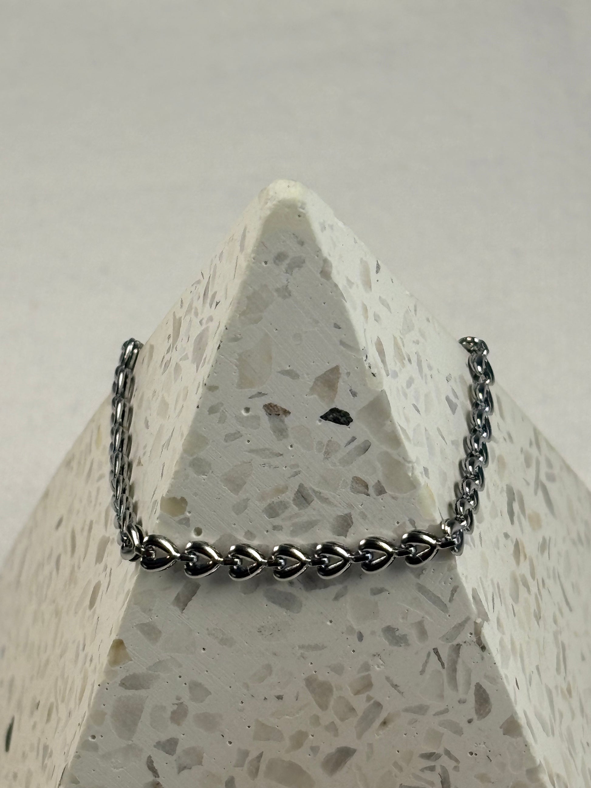 Silver chain bracelet on a textured stone surface