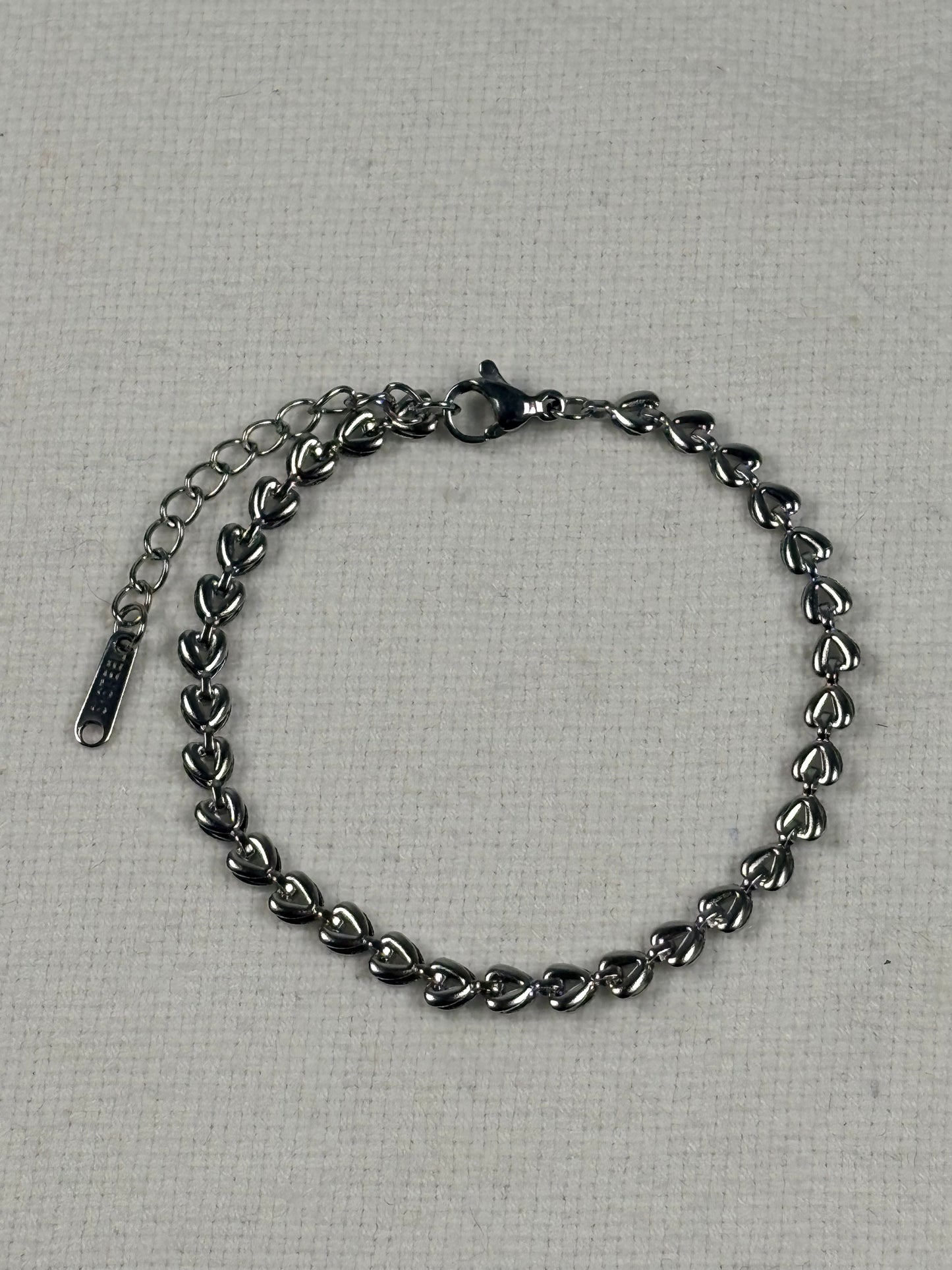 Silver chain bracelet on a textured gray background