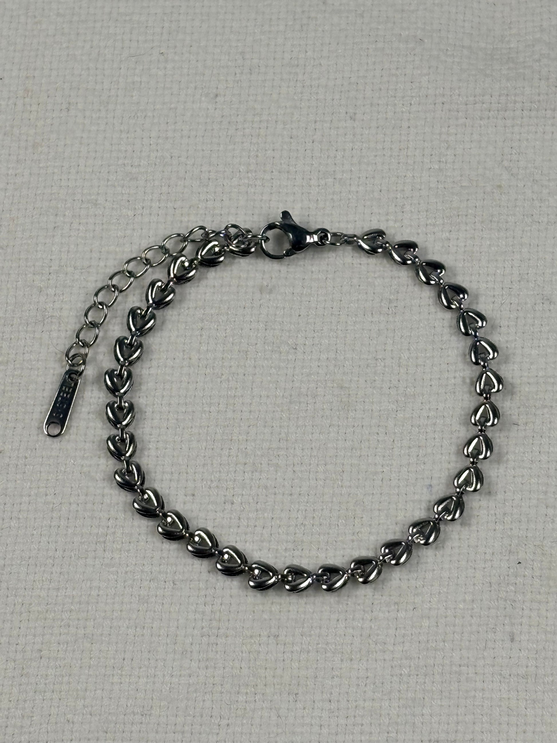 Silver chain bracelet on a textured gray background