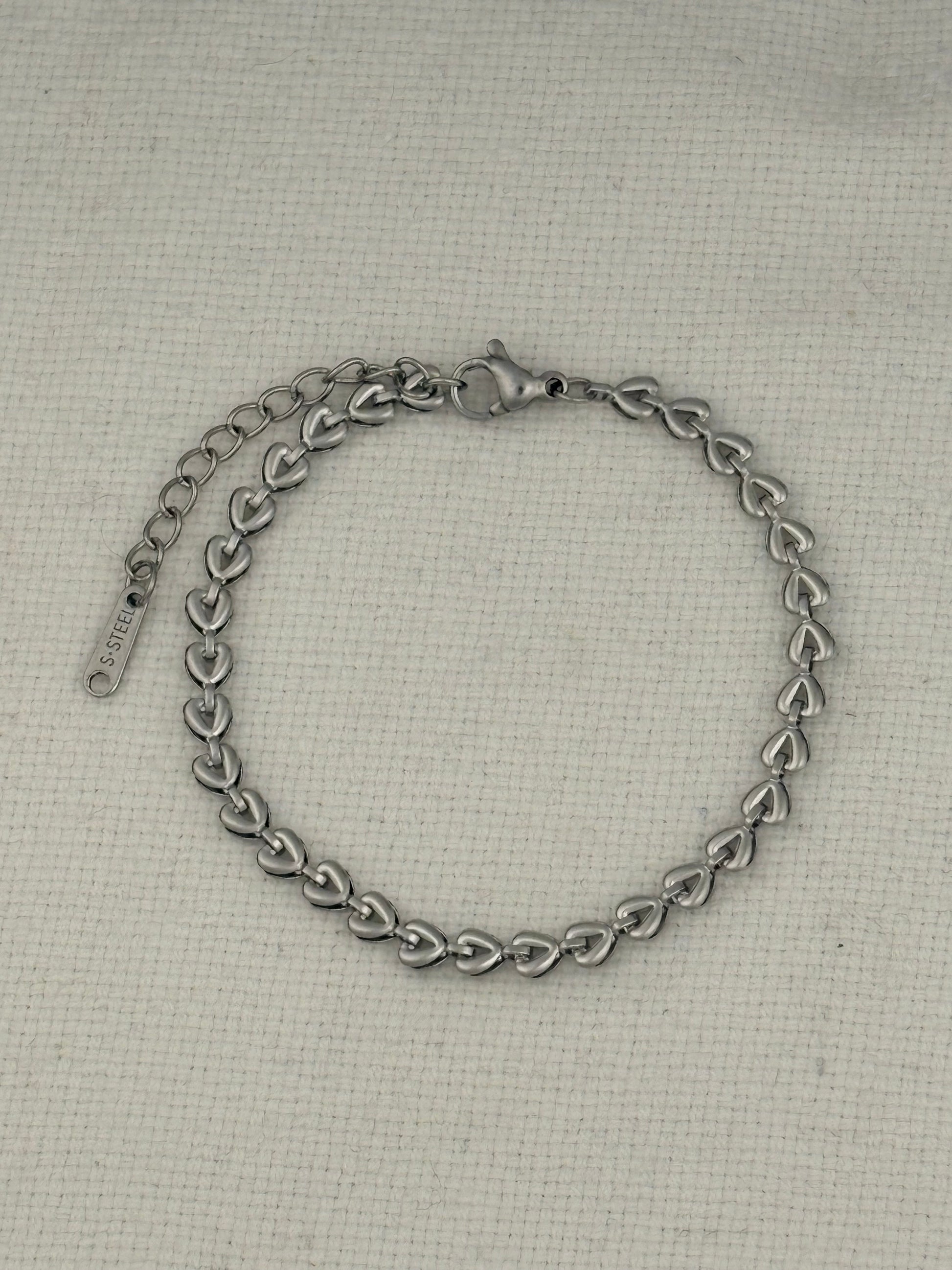 Silver chain bracelet on a textured beige background
